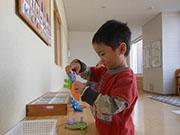 男の子が紫色の洗濯ばさみのようなおもちゃで遊んでいる写真