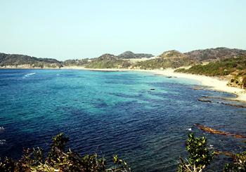 日中の明るい青い海の奥に岬がある風景写真