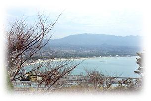 丘の上から見下ろした海の向こうに山々がある福津市の風景写真