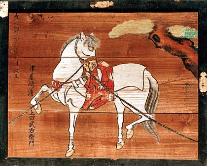 木の板に白い馬の絵が描いてある繋馬図の写真