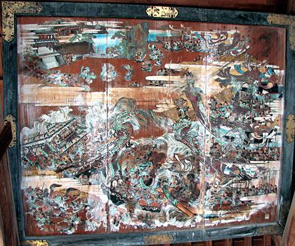 木の板の船に沢山の人が乗っている絵が描かれている八幡縁起図の写真