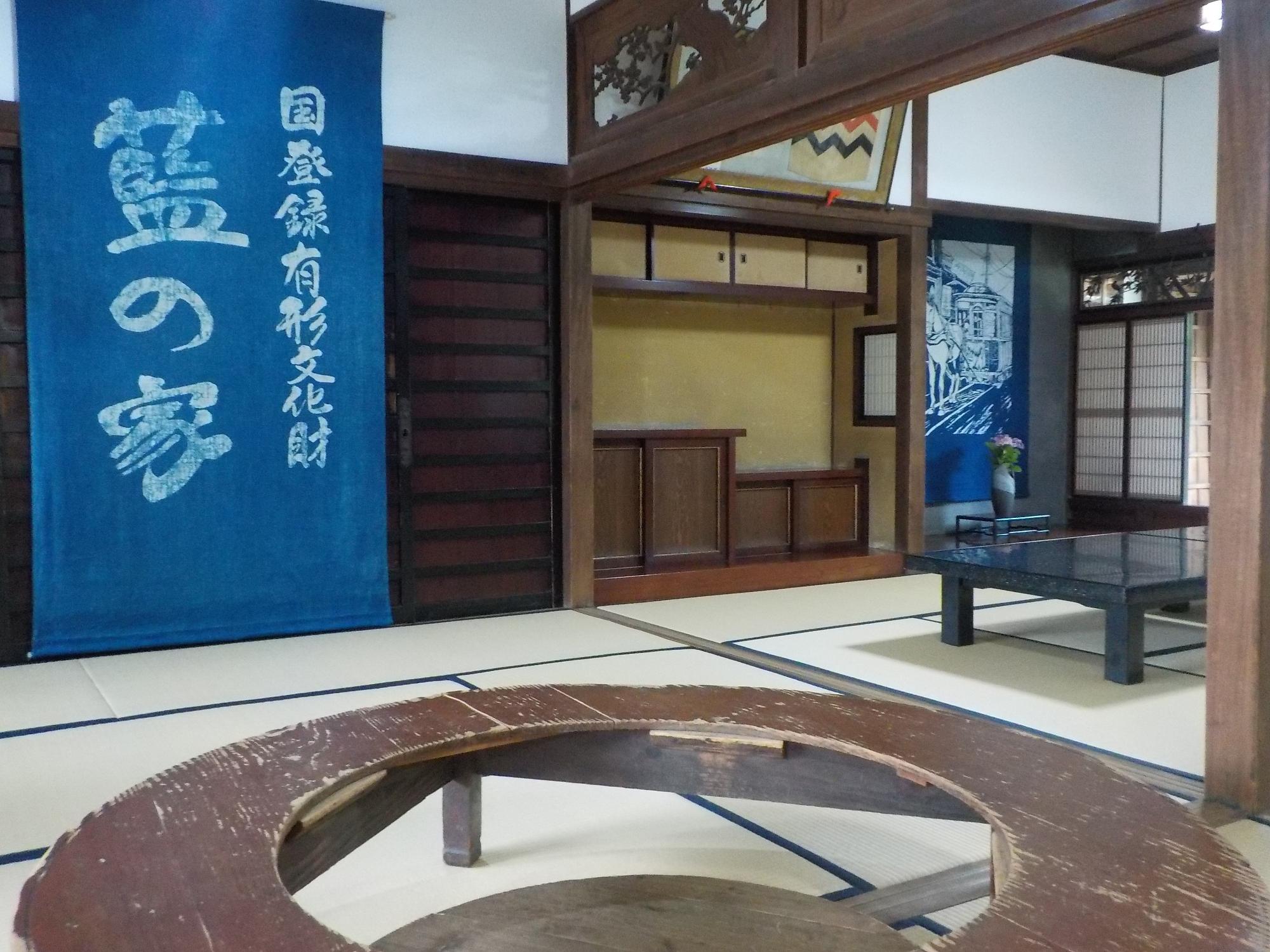 和室に「国登録有形文化財藍の家」と書かれた藍染めの布が飾られている写真