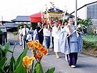 五穀豊穣を願って、お神輿を男性陣で担いで地区内を歩いている写真