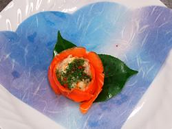 里芋をサーモンで包み、白い大きなお皿に花のように盛り付けられた写真