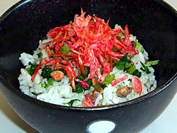 大豆菜飯の上に大根葉や桜エビが飾られ黒い器に盛り付けられている写真