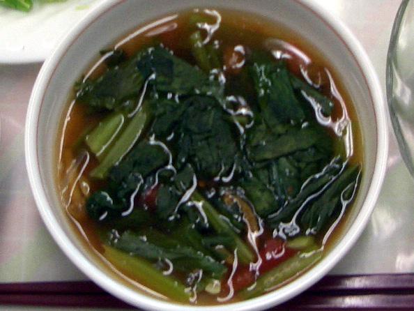 白いカップの中に小松菜、なめこ、干しエビなどが入ったスープの写真