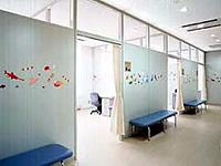白い壁に飾り付けされており、青色の長椅子が設置してあるすくすくルーム（検診室）の待合室の写真